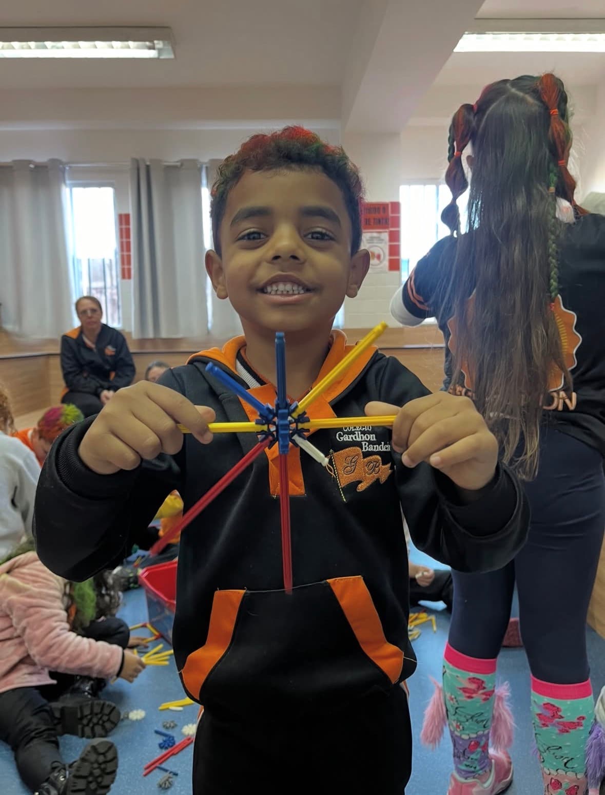 Aluno sorrindo com montagem de brinquedo educativo