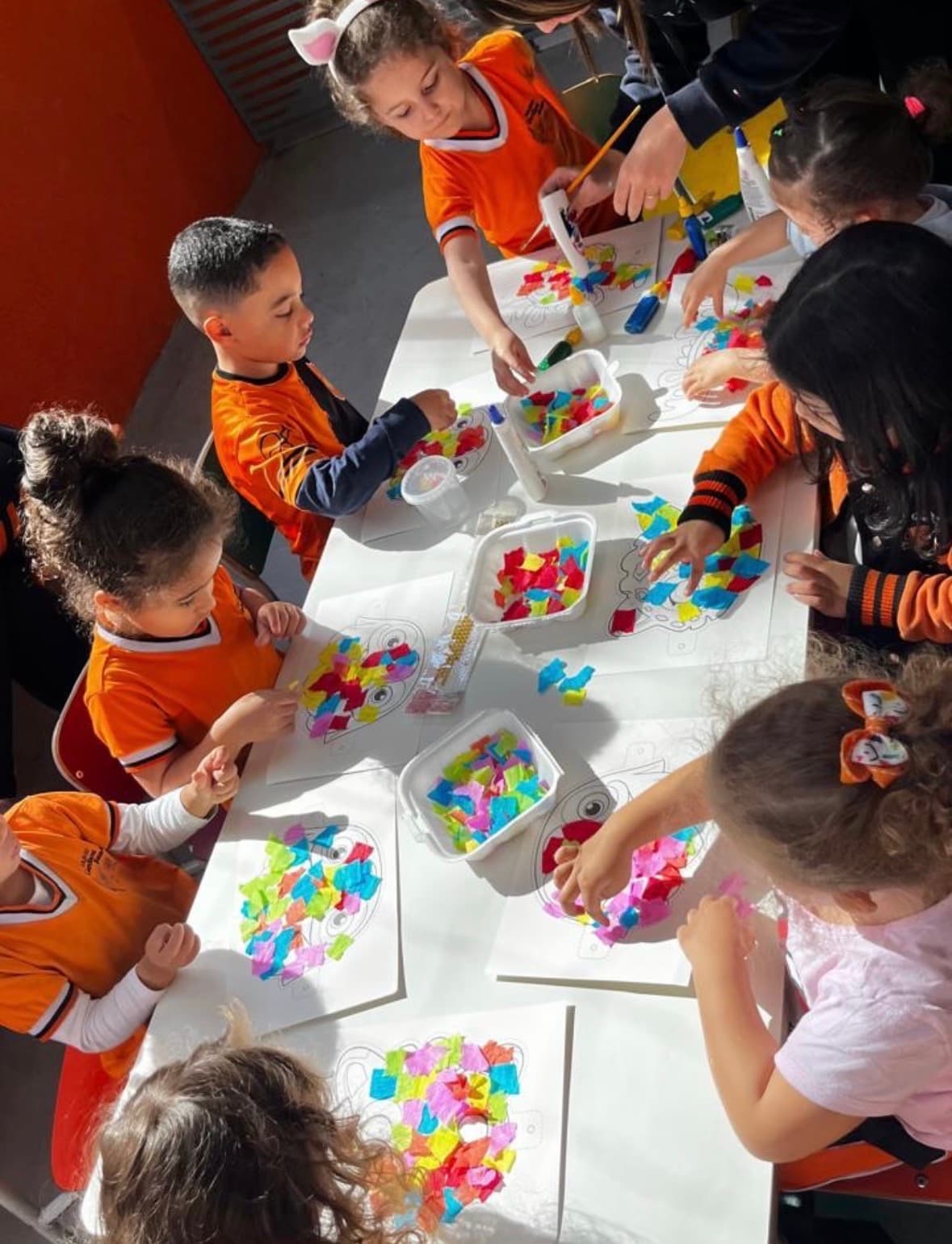 Alunos fazendo atividade de colagem e arte