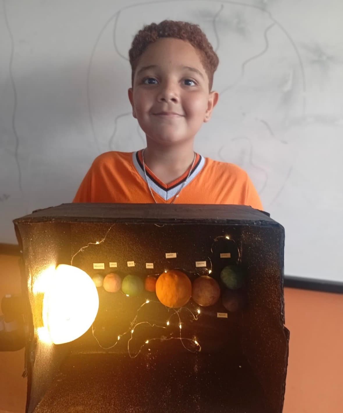 Aluno apresentando projeto de sistema solar