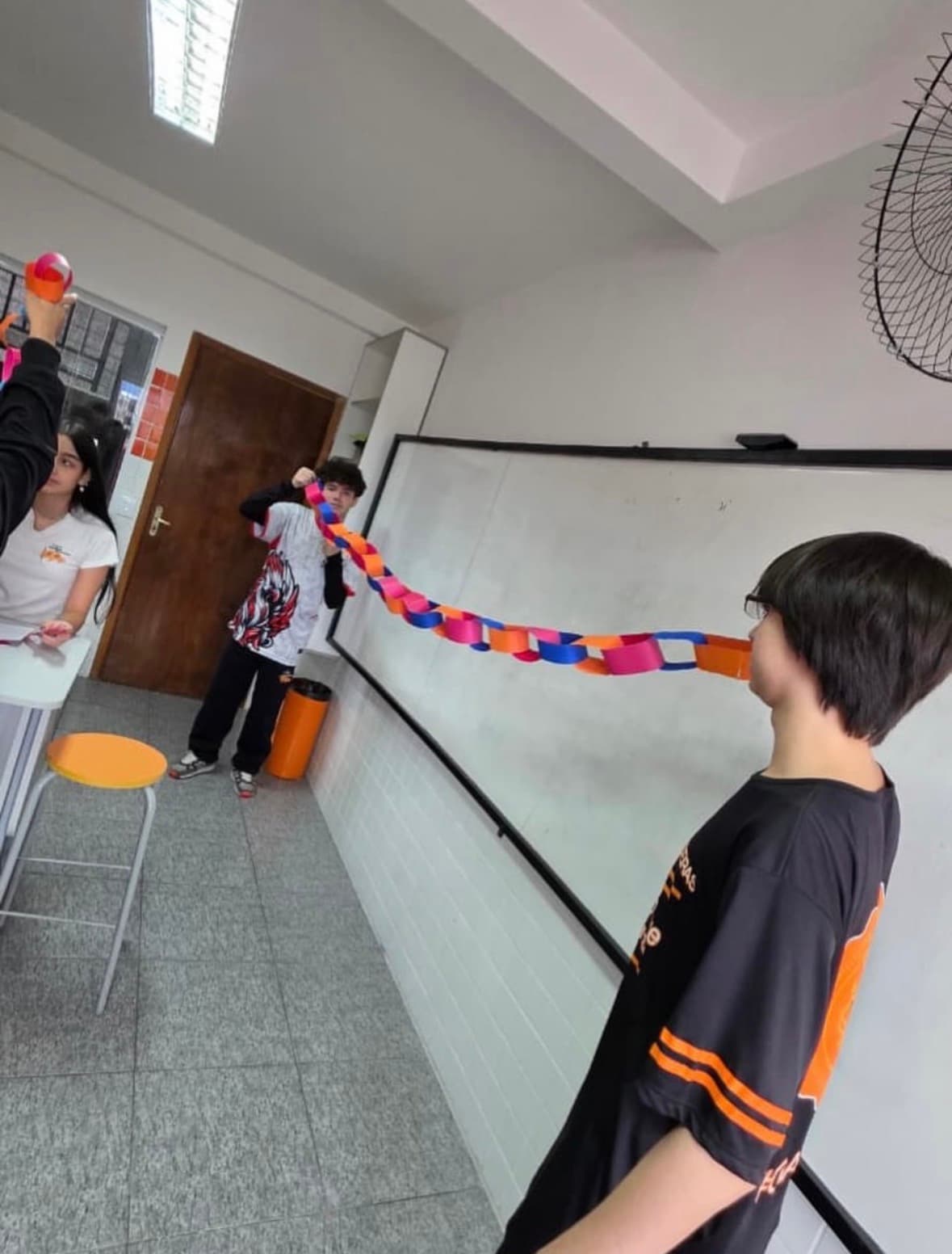 Alunos criando corrente de papel em sala